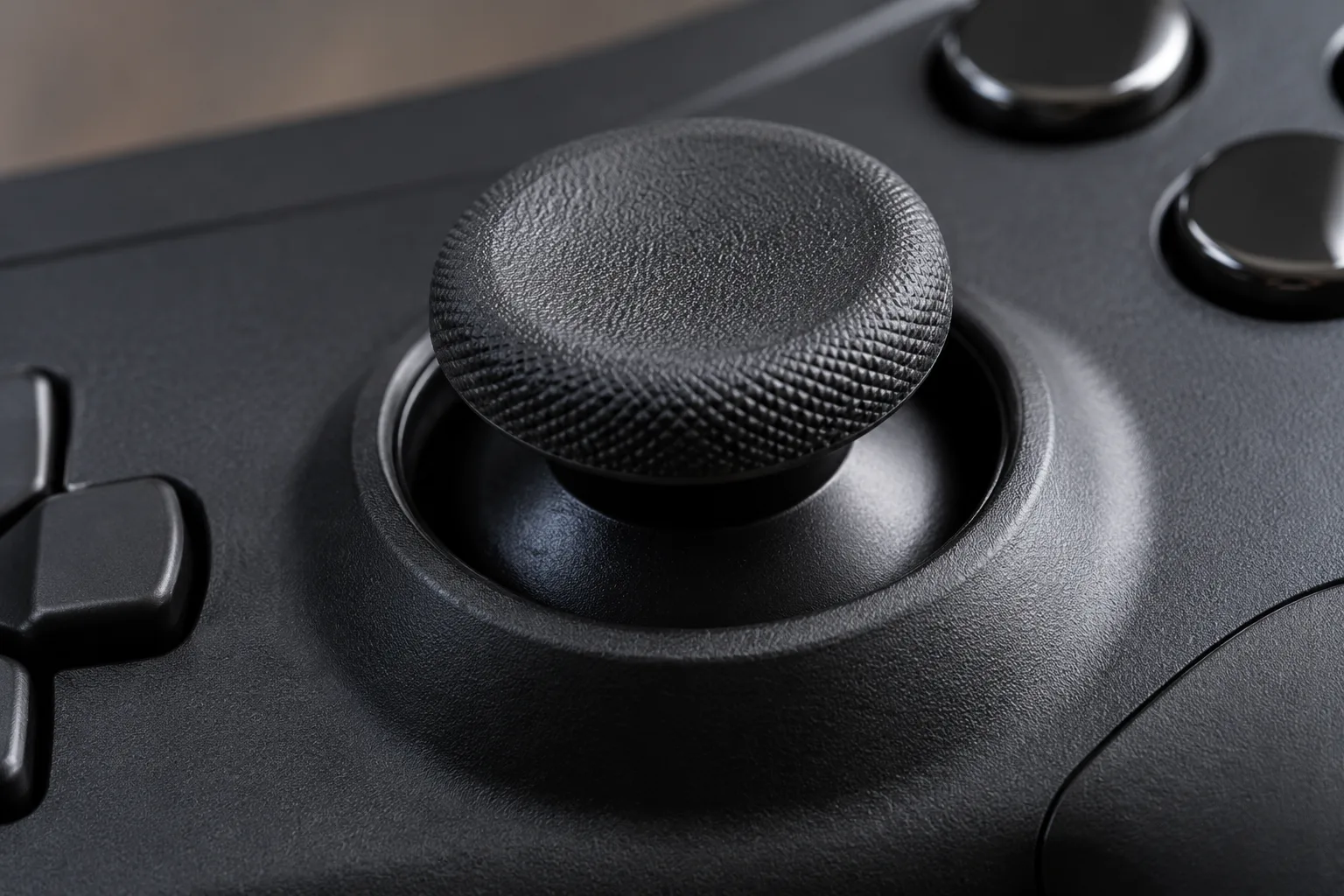 Close view of a thumbstick cap and the surrounding grip on an unlabeled controller.