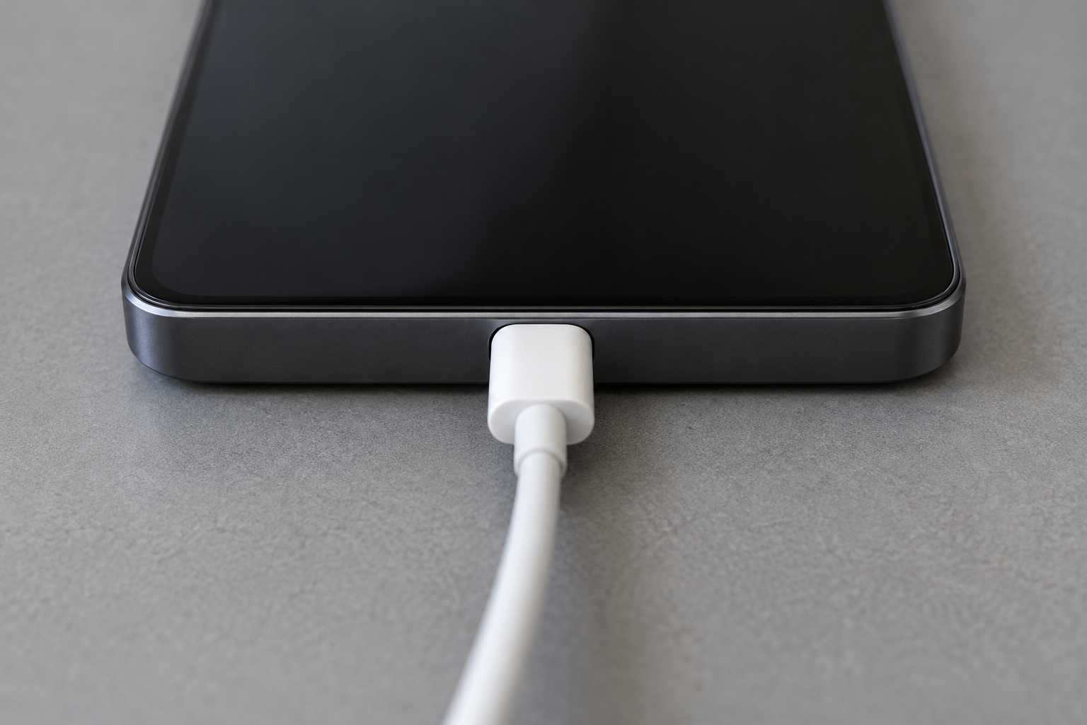 Close view of a plain white USB-C cable seated in the single centered port on the blank bottom edge of a generic Android phone.