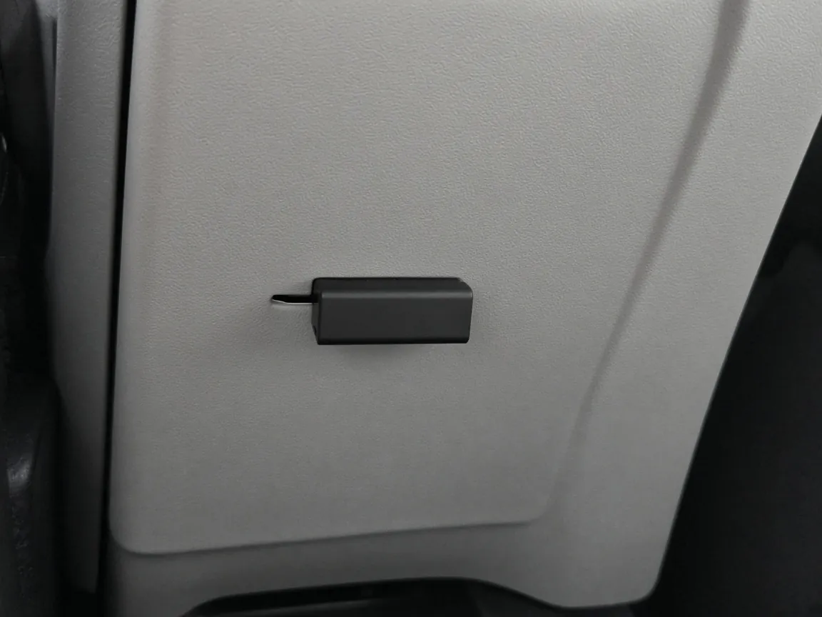 A small black dongle in a gray console panel.